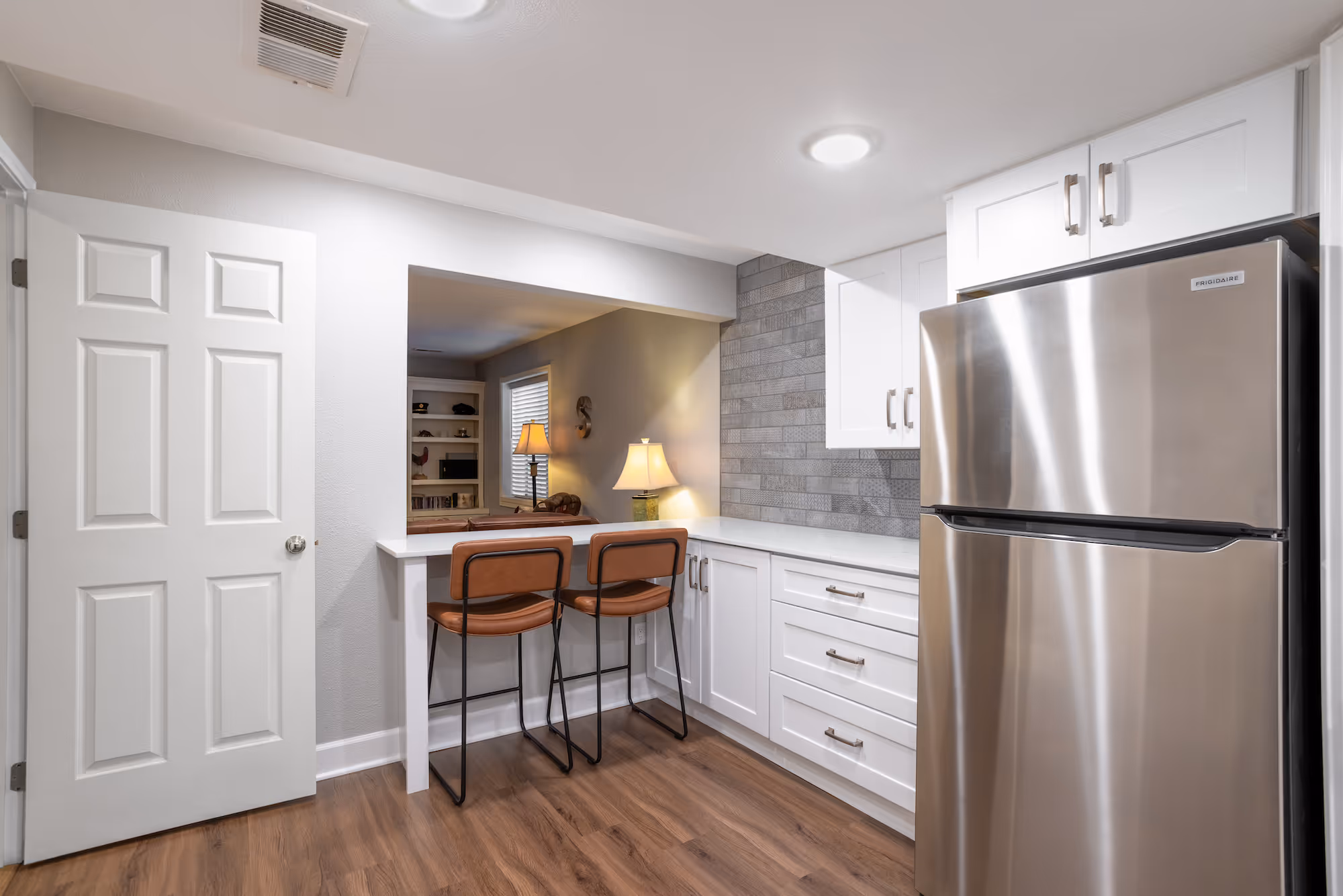 Small kitchenette or wet bar with a sink and cabinetry.