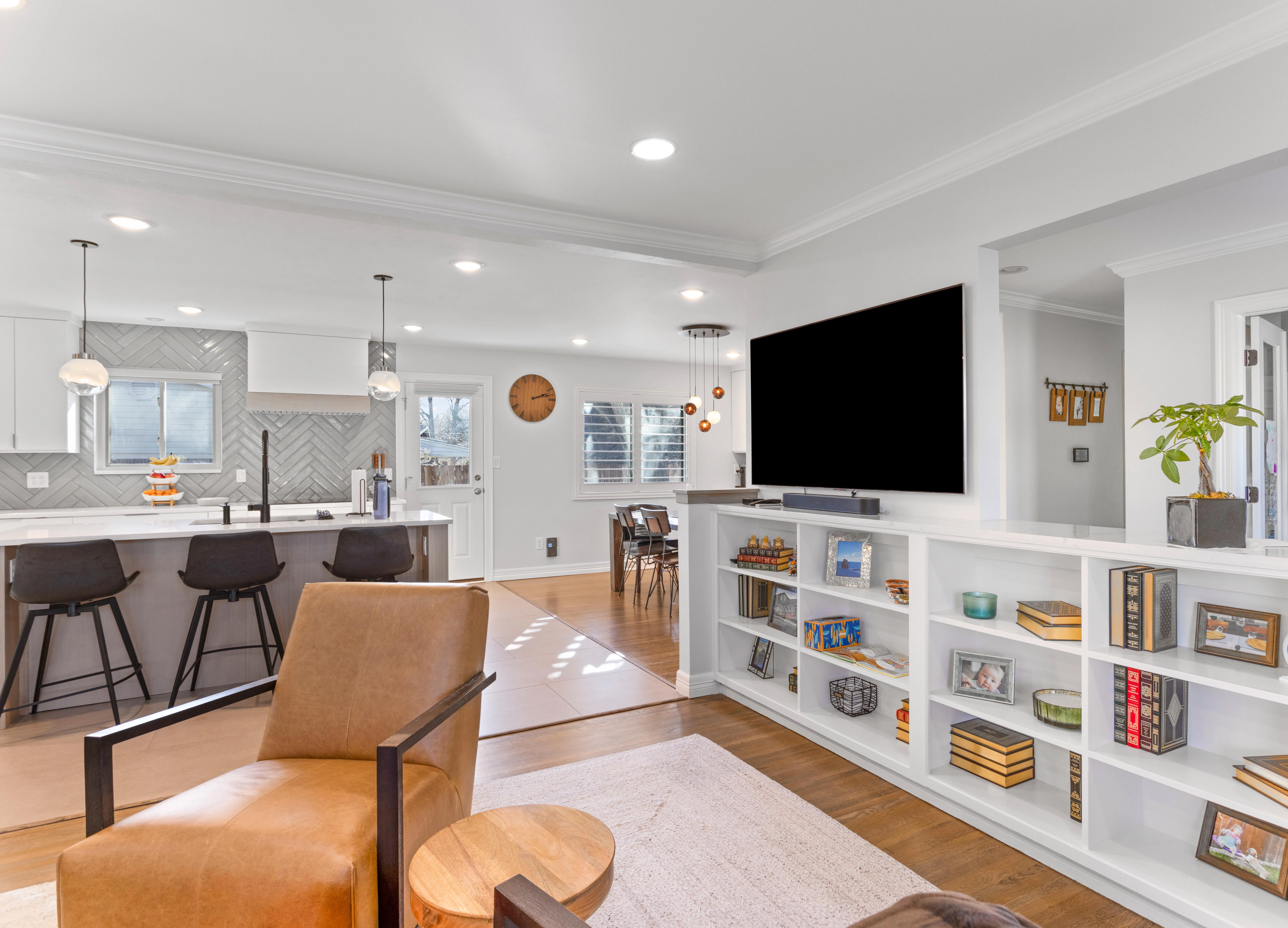 Modern white kitchen renovation with subway tile backsplash and stainless steel appliances.