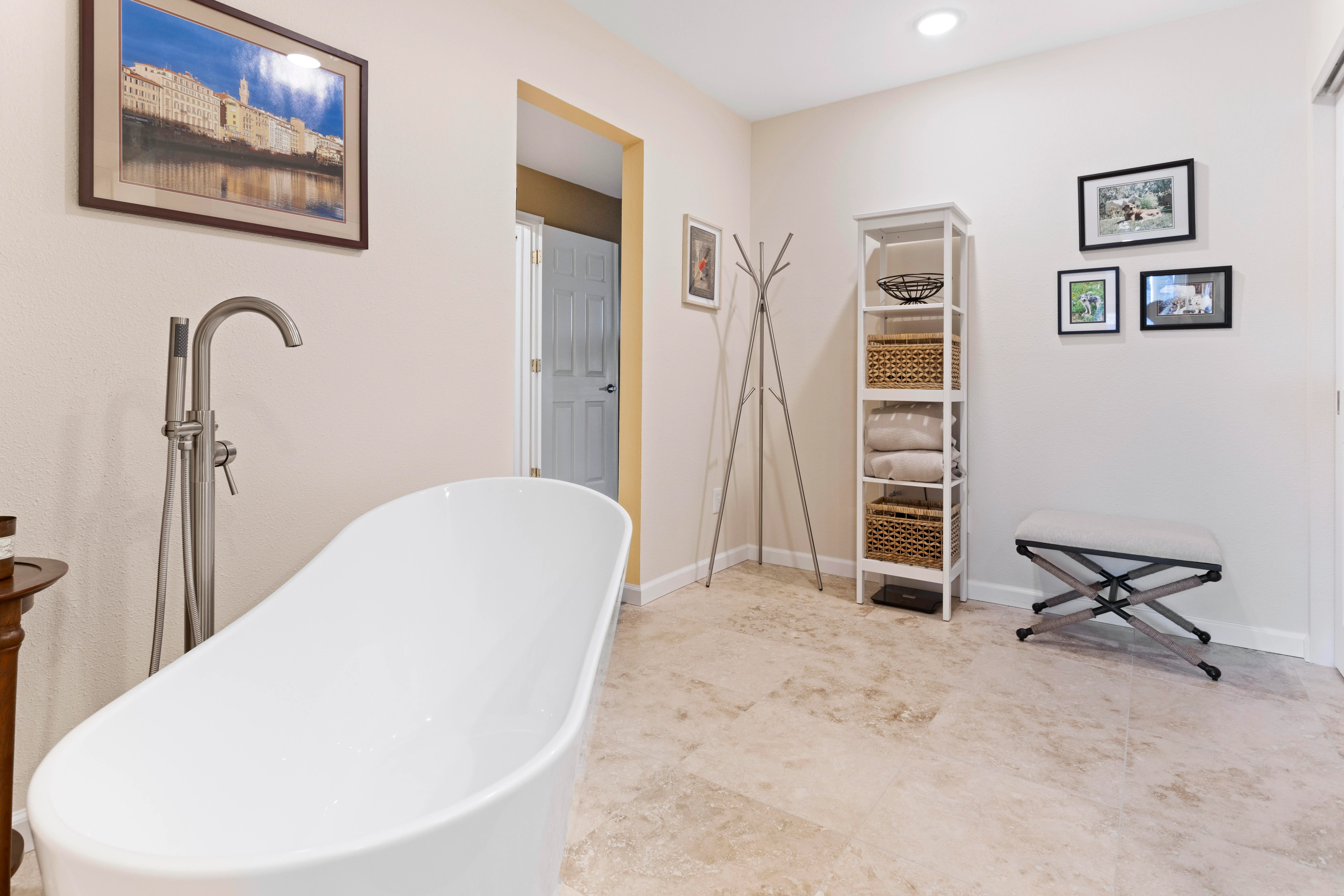 Primary bathroom with a large freestanding tub and a statement chandelier.
