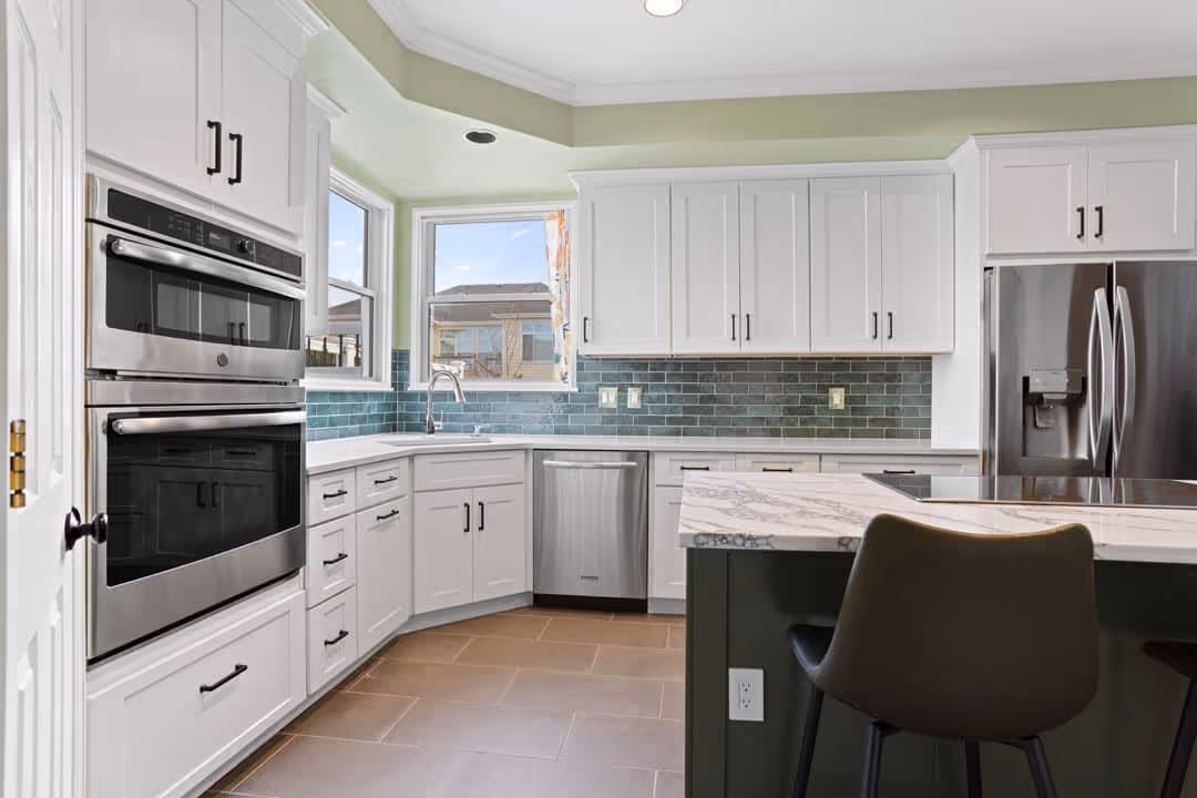 Dining room with a modern chandelier and a large window.
